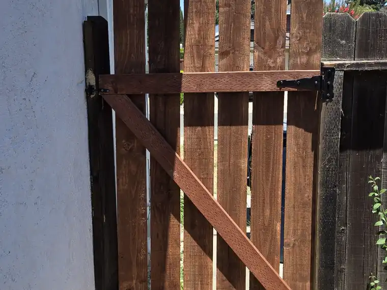 Wooden gate rebuilt with a new diagonal brace